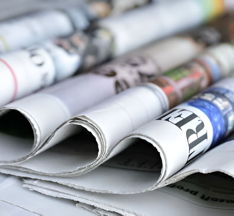 Stack of folded newspapers: old school, we know!